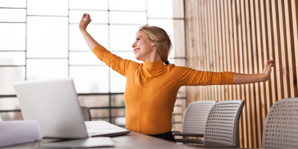 office woman in yellow shirt stretching arms